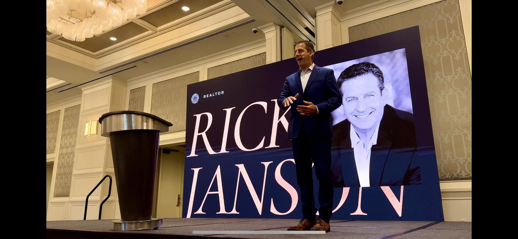 Rick Janson speaking on stage at Magnifica